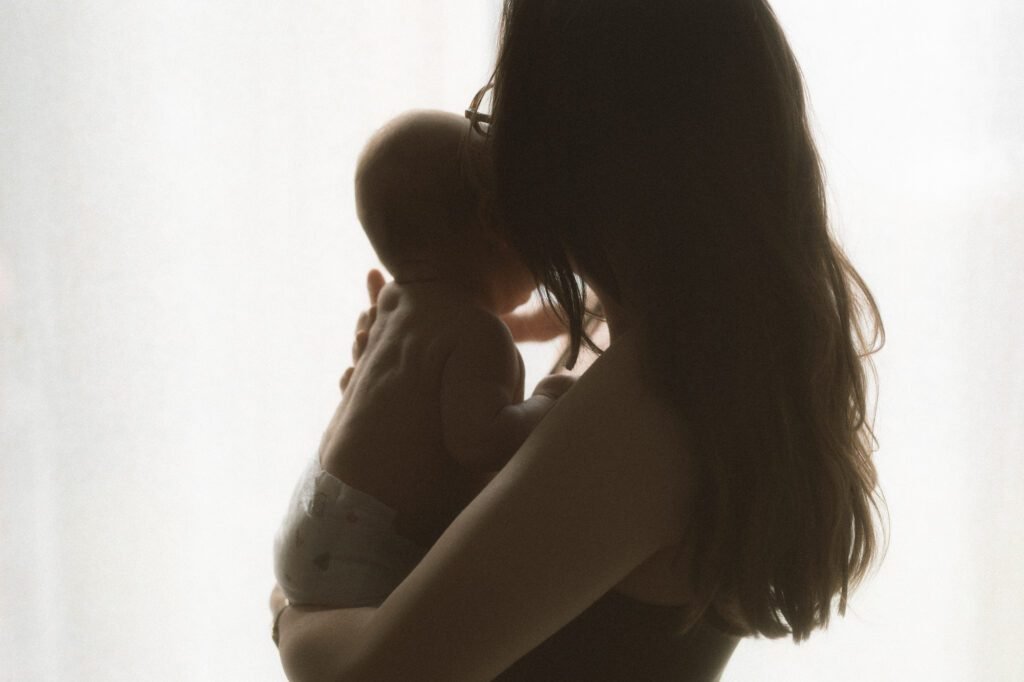 maman en contre jour avec son bébé dans les bras